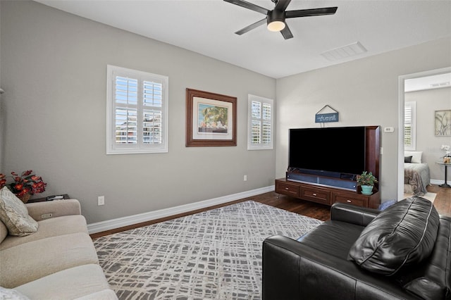 living room featuring dark wood-type flooring and ceiling fan