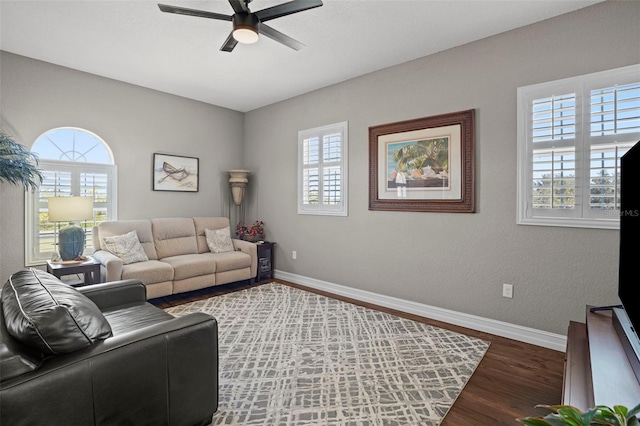 living room featuring dark hardwood / wood-style flooring, ceiling fan, and a wealth of natural light