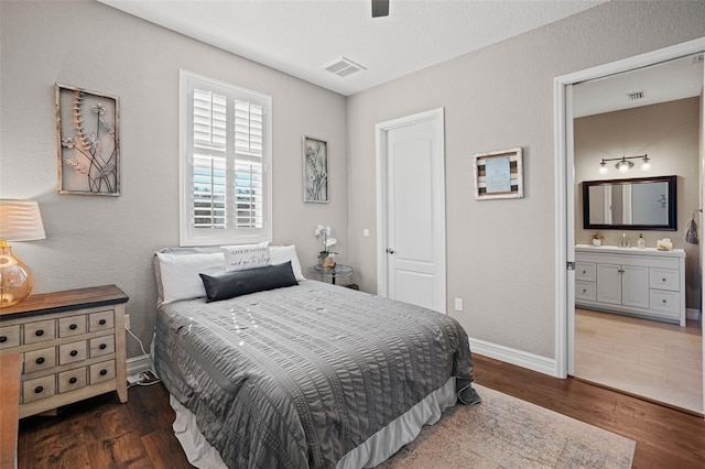 bedroom featuring ensuite bathroom, ceiling fan, dark hardwood / wood-style flooring, and sink