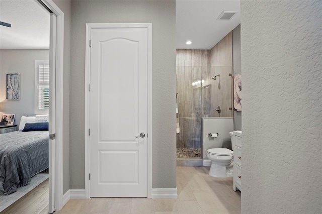 bathroom with an enclosed shower, vanity, and toilet