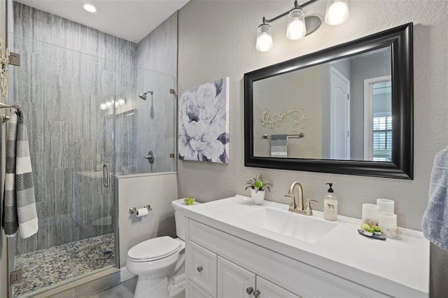 bathroom featuring an enclosed shower, vanity, and toilet