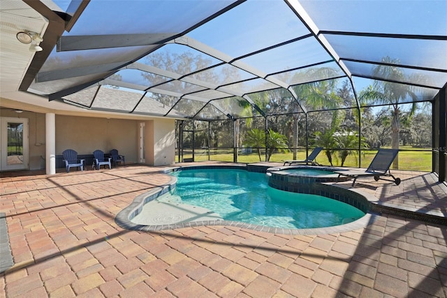 view of swimming pool featuring a lanai, an in ground hot tub, and a patio area