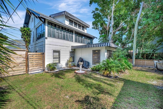 back of property featuring a yard and a sunroom