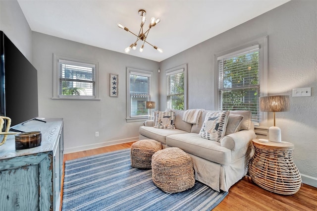 living room with hardwood / wood-style floors and a notable chandelier