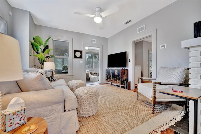 living room with a fireplace and ceiling fan