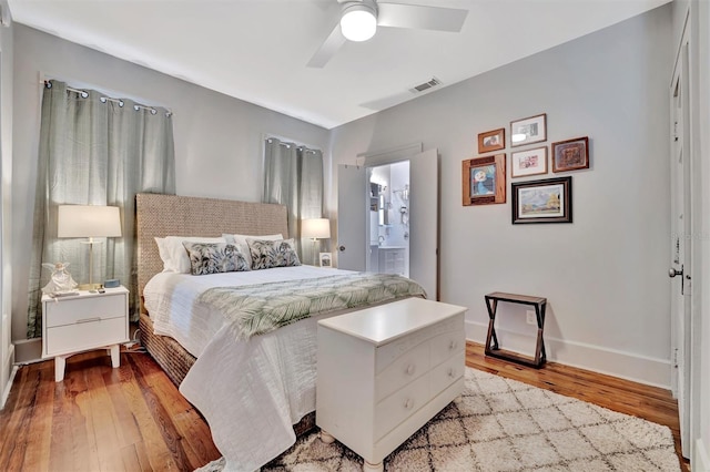 bedroom with light wood-type flooring, ensuite bath, and ceiling fan