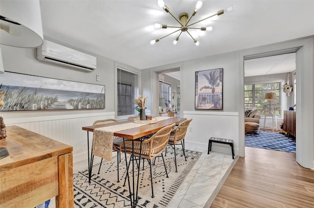 dining area featuring a wall mounted air conditioner and an inviting chandelier