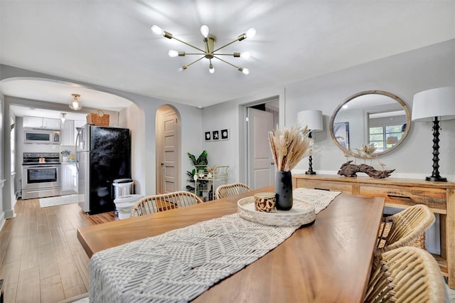 dining area featuring light hardwood / wood-style flooring and a notable chandelier