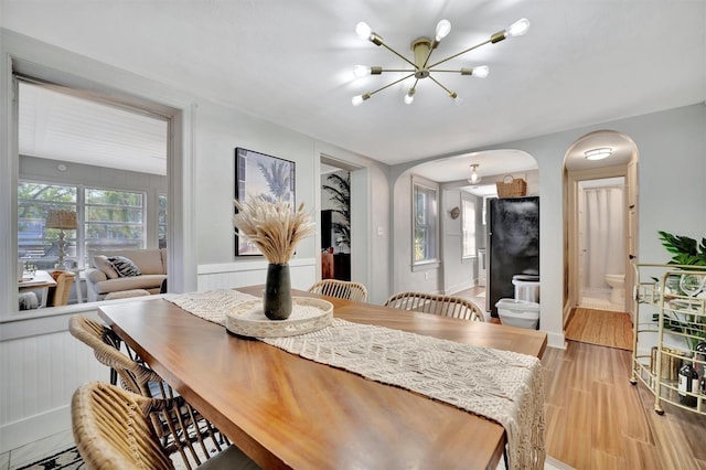 dining area featuring light wood-type flooring and an inviting chandelier