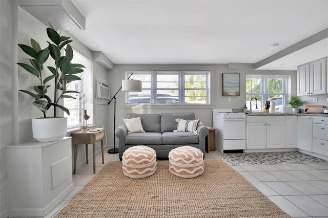 living room with a wall mounted AC, a wealth of natural light, and light tile patterned floors