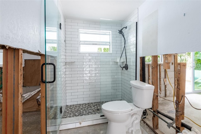 bathroom featuring a shower with shower door, concrete flooring, toilet, and a baseboard radiator