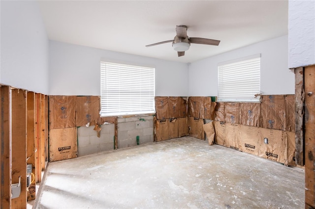 spare room with ceiling fan and concrete floors