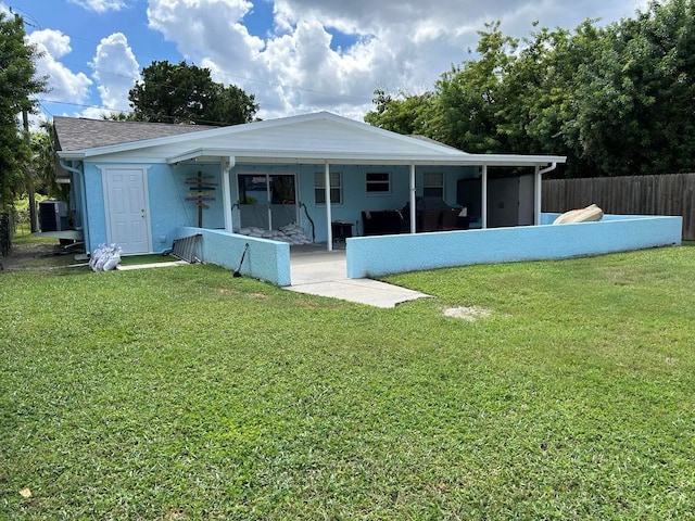 back of property with a yard and a sunroom