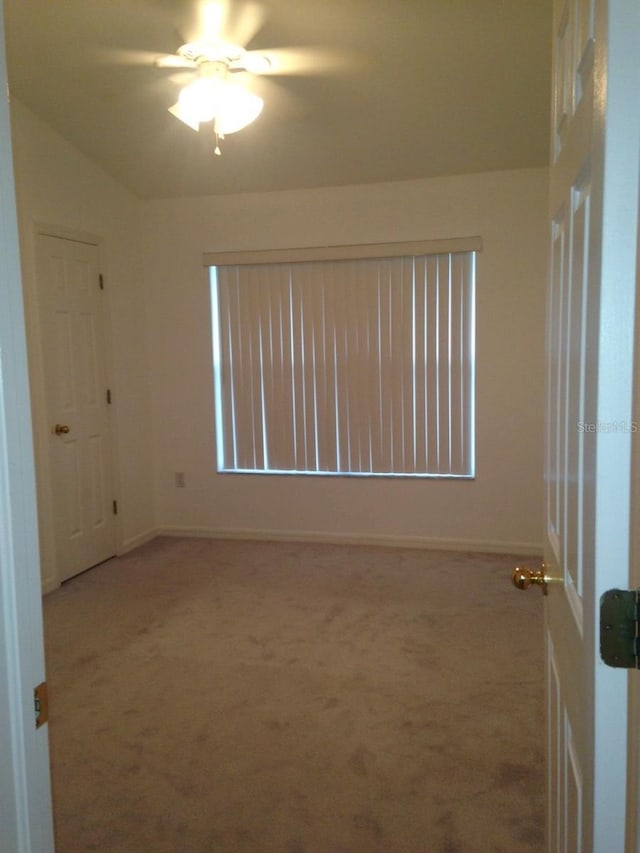 spare room with light carpet, ceiling fan, and lofted ceiling