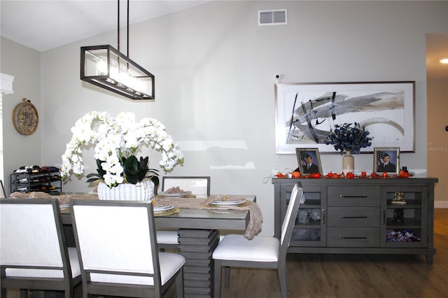 dining space with dark hardwood / wood-style floors and vaulted ceiling