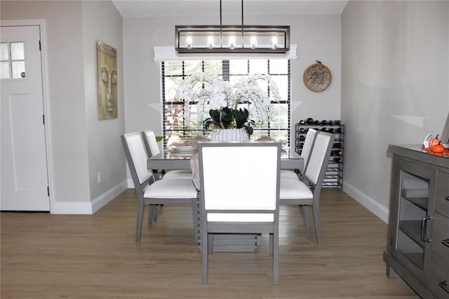 dining space featuring plenty of natural light, light hardwood / wood-style flooring, and a notable chandelier