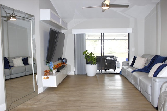 living room with ceiling fan, light hardwood / wood-style floors, and lofted ceiling