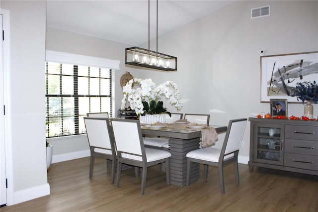 dining area with vaulted ceiling and dark hardwood / wood-style flooring