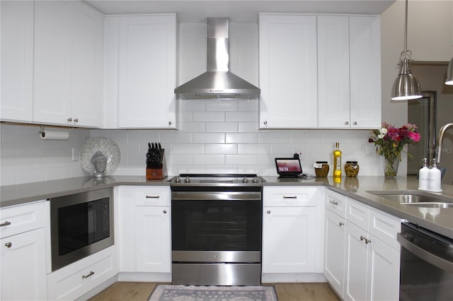 kitchen with stainless steel electric range oven, backsplash, dishwasher, built in microwave, and wall chimney range hood