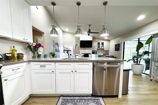 kitchen with pendant lighting, white cabinets, decorative backsplash, vaulted ceiling, and stainless steel dishwasher