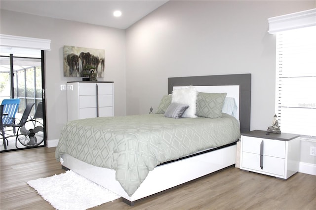 bedroom featuring access to exterior and wood-type flooring