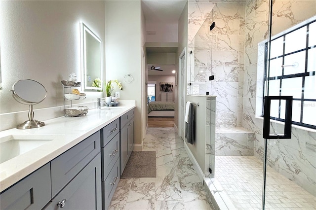 bathroom with a shower with shower door, vanity, and a healthy amount of sunlight