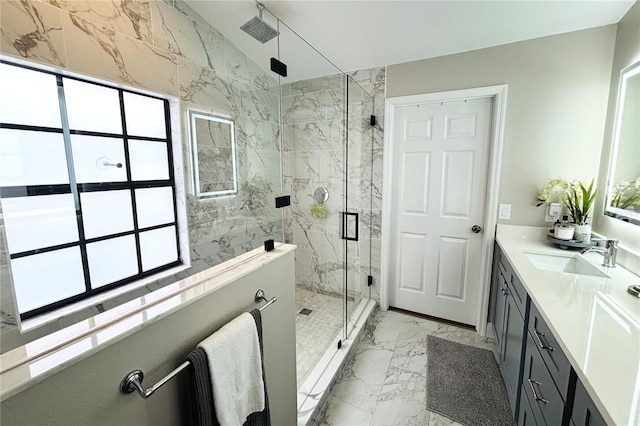 bathroom with a healthy amount of sunlight, a shower with shower door, and vanity