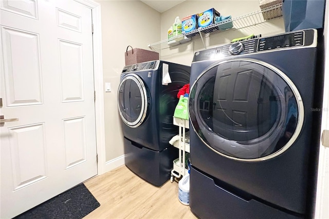 clothes washing area featuring light wood-type flooring and washing machine and clothes dryer