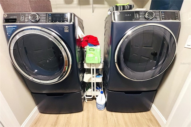 washroom with independent washer and dryer and hardwood / wood-style flooring