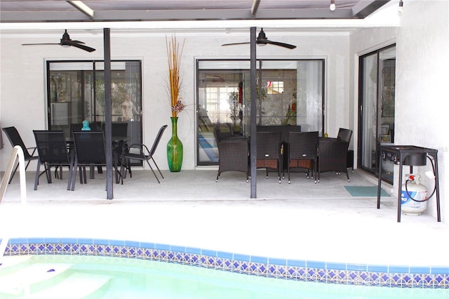 view of swimming pool with ceiling fan and a patio