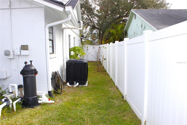 view of side of home with a lawn and central AC unit