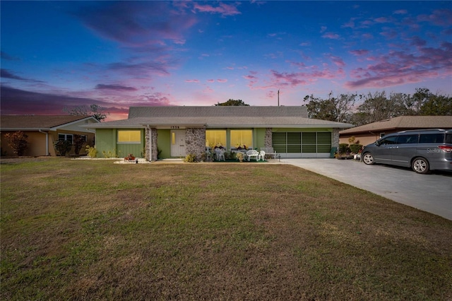 ranch-style house featuring a lawn and a garage