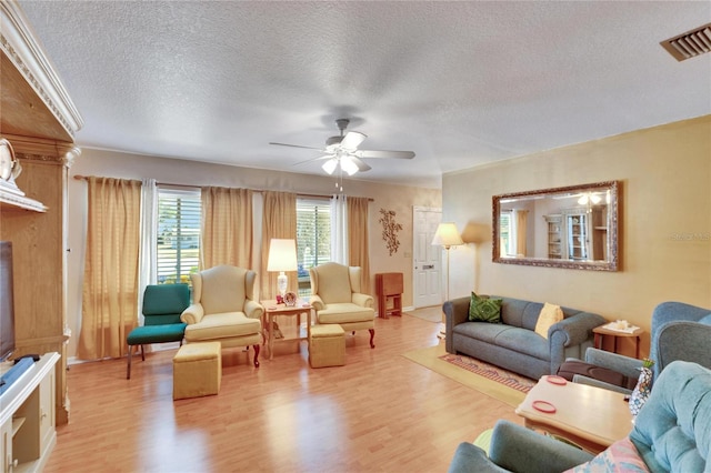 living room featuring a textured ceiling, ceiling fan, and light hardwood / wood-style flooring