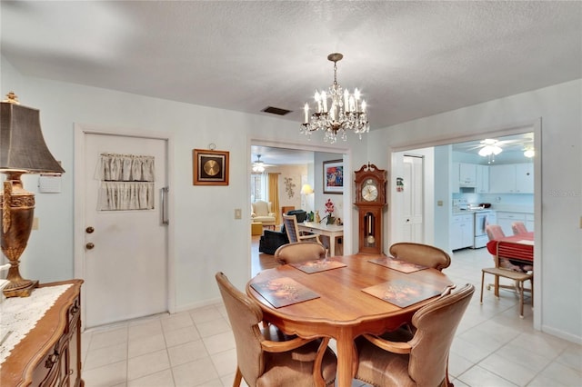 dining room with a textured ceiling, light tile patterned flooring, and ceiling fan with notable chandelier