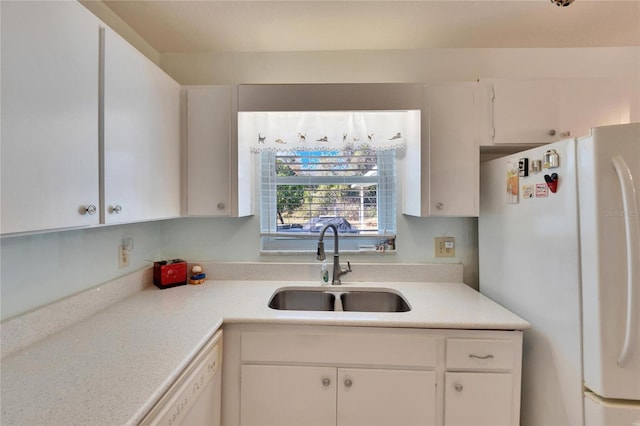 kitchen featuring white appliances, white cabinetry, and sink