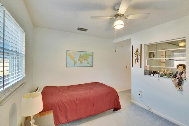 bedroom featuring a textured ceiling, ceiling fan, and carpet