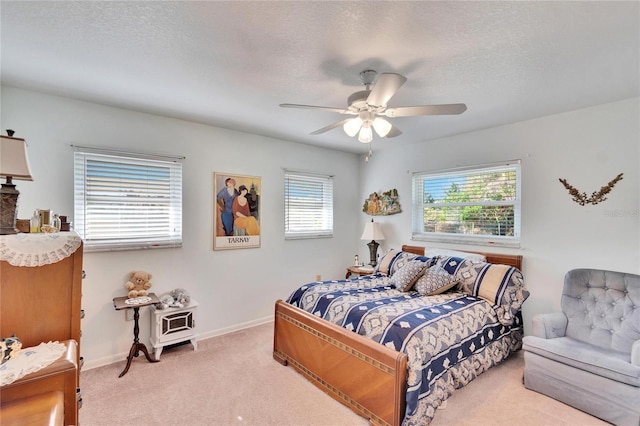 bedroom featuring a textured ceiling, ceiling fan, and light carpet