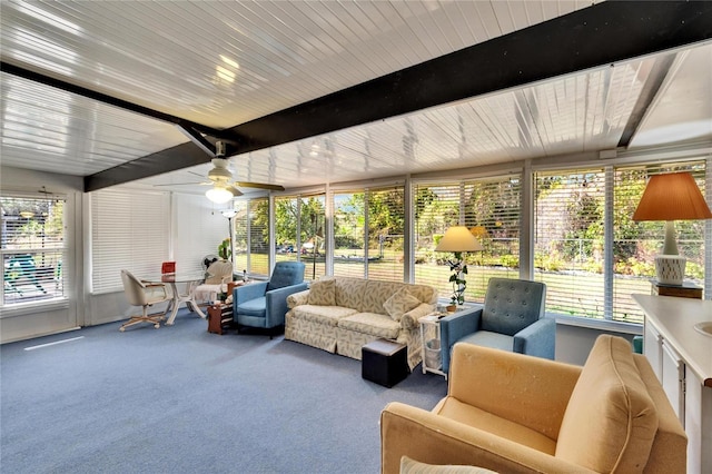 sunroom with ceiling fan and beam ceiling