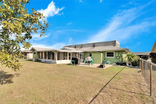 back of house featuring a patio area, a yard, and a sunroom