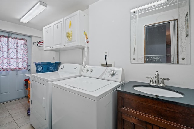 clothes washing area with sink, light tile patterned flooring, washing machine and clothes dryer, and cabinets