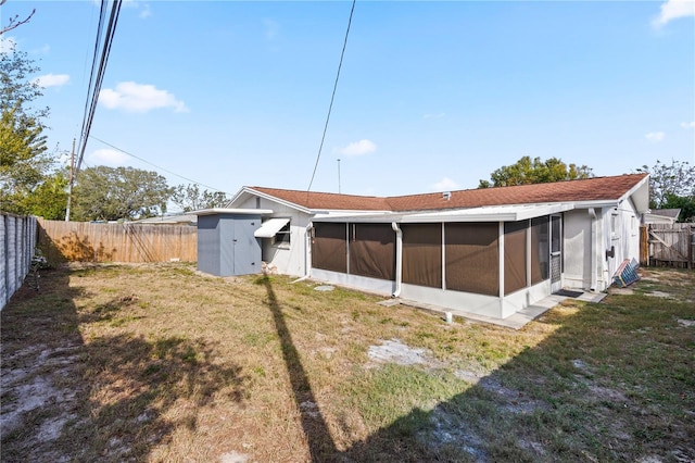 rear view of property featuring a yard and a sunroom