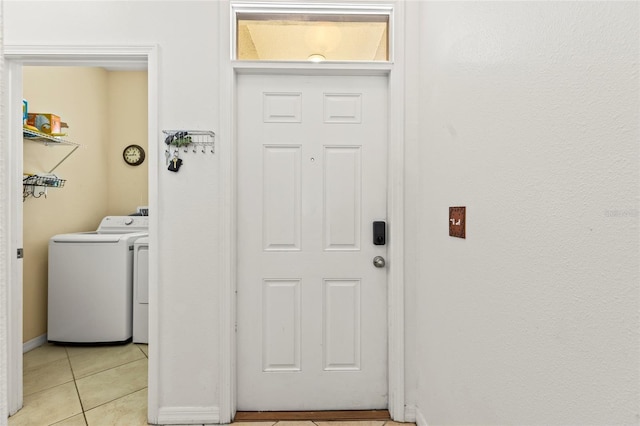 clothes washing area featuring washer and clothes dryer and light tile patterned floors