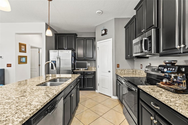 kitchen with sink, a textured ceiling, light tile patterned flooring, pendant lighting, and appliances with stainless steel finishes