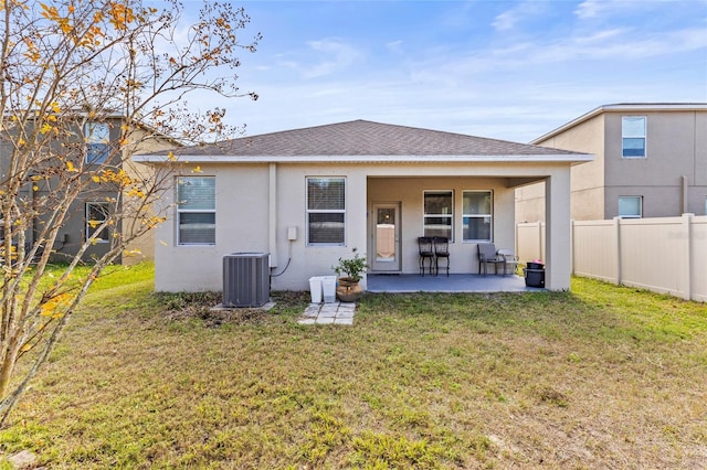 back of property featuring a yard, a patio area, and cooling unit