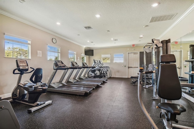 workout area featuring a textured ceiling, ornamental molding, and plenty of natural light