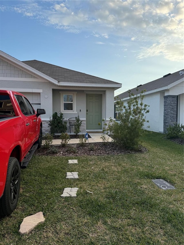 ranch-style house featuring covered porch and a front lawn