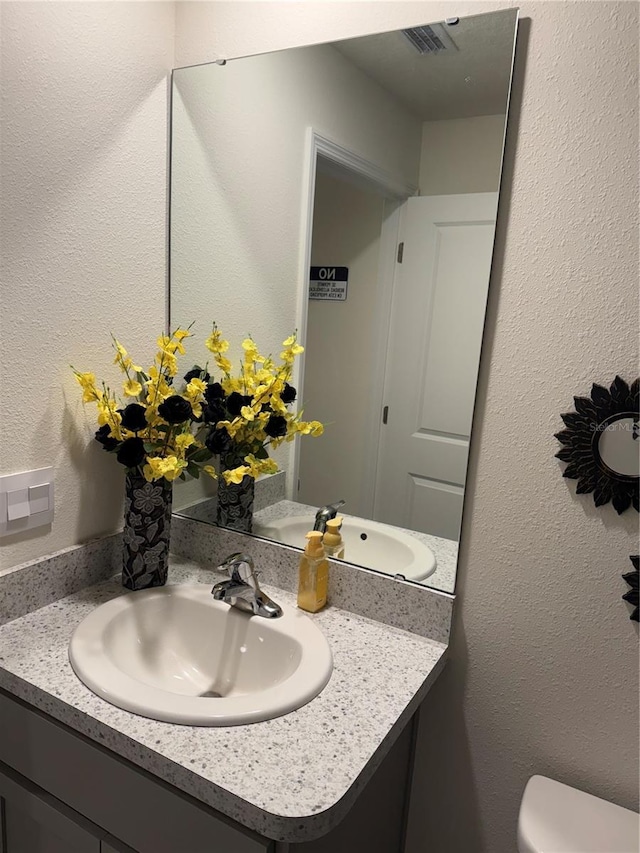 bathroom featuring vanity and toilet