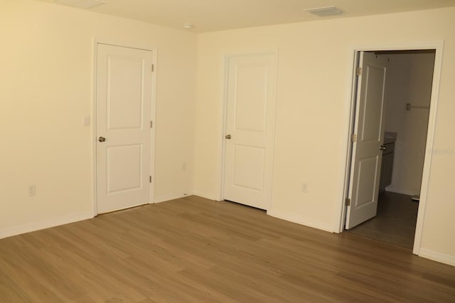 unfurnished bedroom with dark hardwood / wood-style flooring