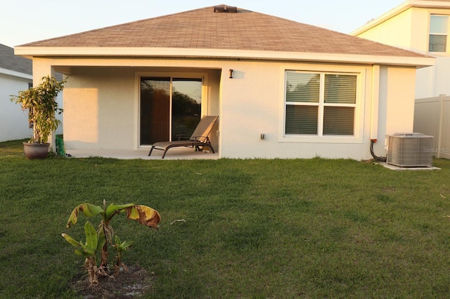 rear view of house with a yard and central AC