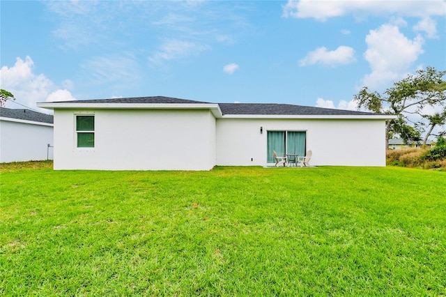 rear view of property featuring a lawn